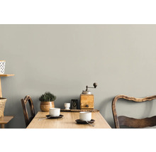Une pièce lumineuse avec une table en bois, deux chaises, des tasses et des décorations murales