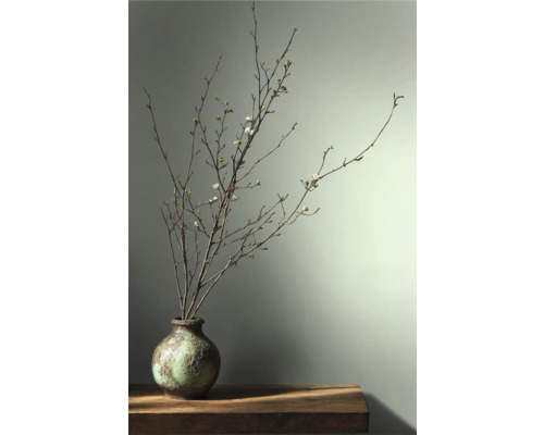 Branches décoratives avec des fleurs dans un vase sur une table