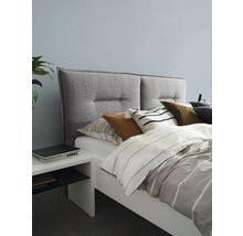 Chambre avec lit, tête de lit rembourrée, coussins et table de chevet
