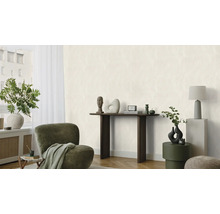 Salon lumineux avec fauteuil, console et objets décoratifs.