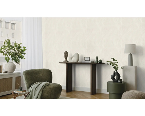 Salon lumineux avec fauteuil, console et objets décoratifs.