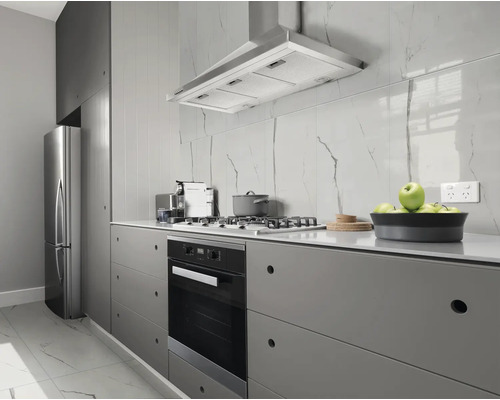 Cuisine moderne avec des appareils en acier inoxydable, une hotte aspirante et des armoires grises.