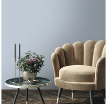 Salon décoratif avec fauteuil et table d'appoint avec arrangement floral.