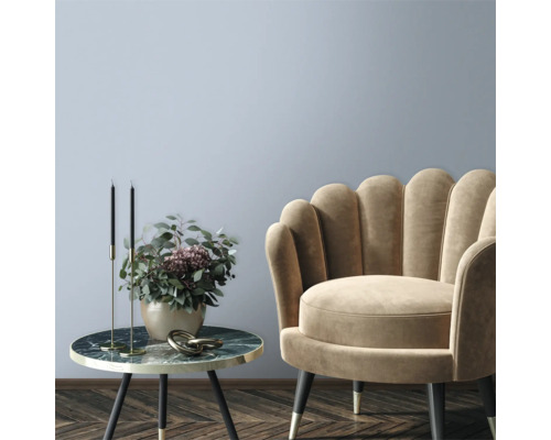 Salon décoratif avec fauteuil et table d'appoint avec arrangement floral.