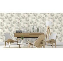 Salon avec papier peint à motifs de feuilles, meubles en bois et décorations pour une ambiance chaleureuse.