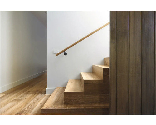 Escalier avec marches en bois et rampe sur un mur blanc