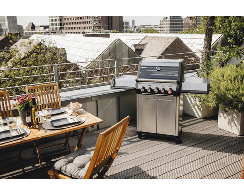 Gril à gaz avec table et chaises sur un toit-terrasse