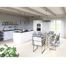 Cuisine lumineuse avec îlot de cuisson, table à manger et chaises dans une pièce spacieuse.