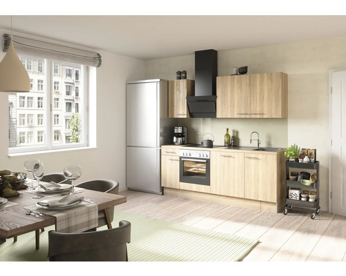 Cuisine claire avec table à manger, kitchenette, réfrigérateur et hotte aspirante.