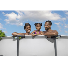 Une famille profite de la baignade dans une piscine hors sol en acier dans le jardin