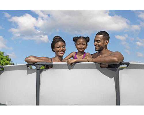 Une famille profite de la baignade dans une piscine hors sol en acier dans le jardin