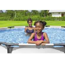 Deux femmes dans une piscine hors sol dans le jardin.