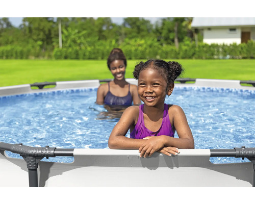 Deux femmes dans une piscine hors sol dans le jardin.