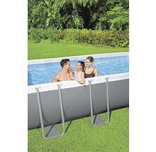 Famille dans une piscine hors sol dans le jardin