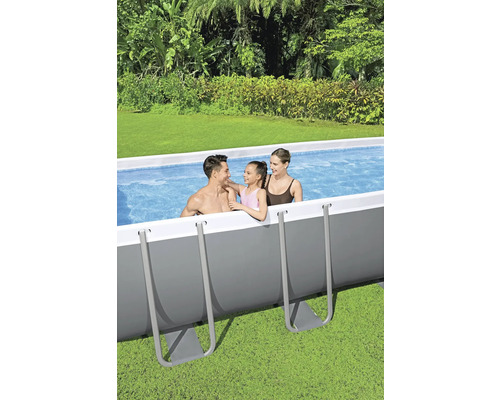 Famille dans une piscine hors sol dans le jardin