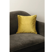 Coussin décoratif jaune en velours sur un fauteuil