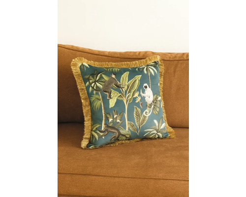 Coussin décoratif à motif jungle avec franges sur un canapé