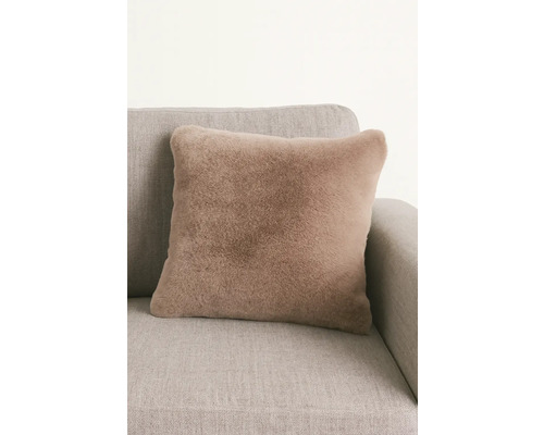 Quadratisches Zierkissen mit Fellimitat auf einer Couch