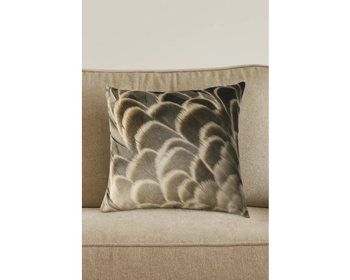 Coussin décoratif carré avec motif de plumes sur un canapé