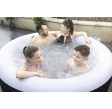 Une famille se détend dans un jacuzzi gonflable dans le jardin.