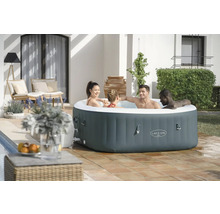 Spa gonflable Lay-Z-Spa avec quatre personnes dans le jardin.