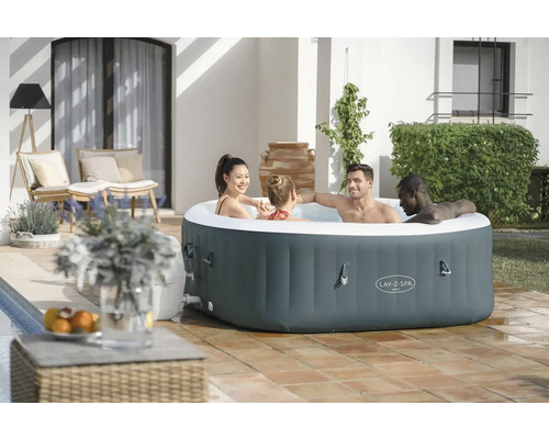 Spa gonflable Lay-Z-Spa avec quatre personnes dans le jardin.