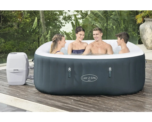 Bain à remous gonflable Lay-Z-Spa Ibiza avec quatre personnes sur une terrasse en bois.