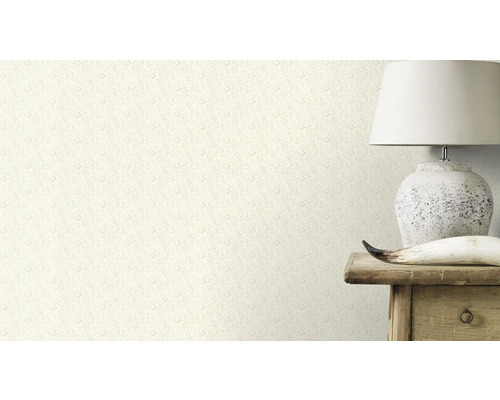Gros plan d'un mur avec un papier peint à motif floral, à côté d'une lampe sur une table en bois