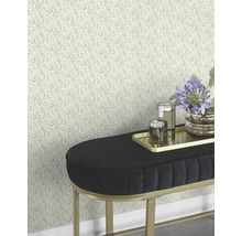 Vue d'une pièce avec papier peint à motifs floraux et banc en velours noir avec cadre doré