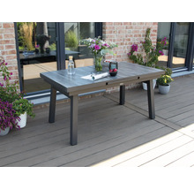 Ausziehbarer Gartentisch auf einer Terrasse mit Blumen und Getränken dekoriert.