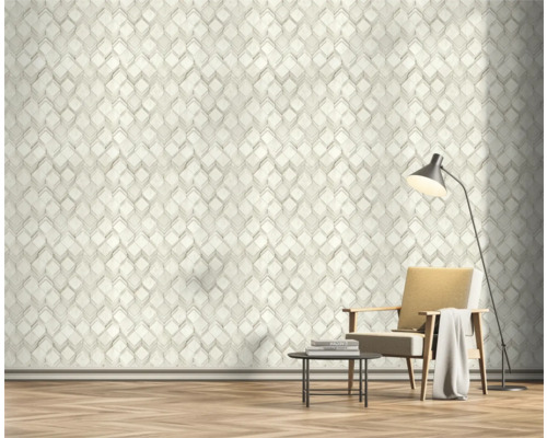 Salon avec papier peint géométrique, fauteuil et lampadaire.