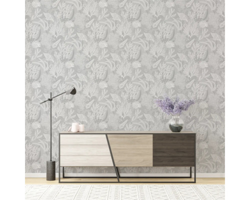 Intérieur avec papier peint à motifs, commode, lampe et tapis