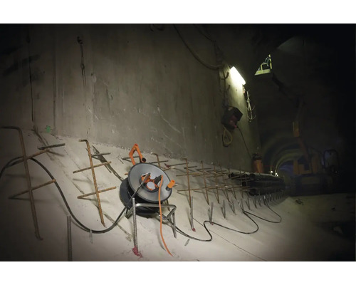 Baustellenszene in einem Tunnel mit Beton, Bewehrungsstahl und Kabeltrommel