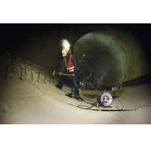 Bauarbeiter mit Werkzeugen in einem Tunnel.