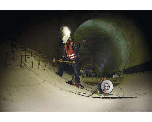Bauarbeiter mit Werkzeugen in einem Tunnel.