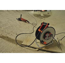 Verlängerungskabeltrommel und Winkelschleifer auf einer Baustelle