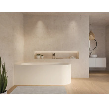 Salle de bain lumineuse avec baignoire îlot, lavabo et niche de rangement