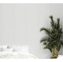 Chambre claire avec lit, plante d'intérieur et mur à structure verticale