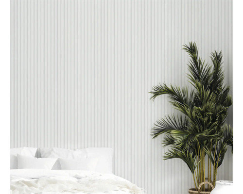 Chambre claire avec lit, plante d'intérieur et mur à structure verticale