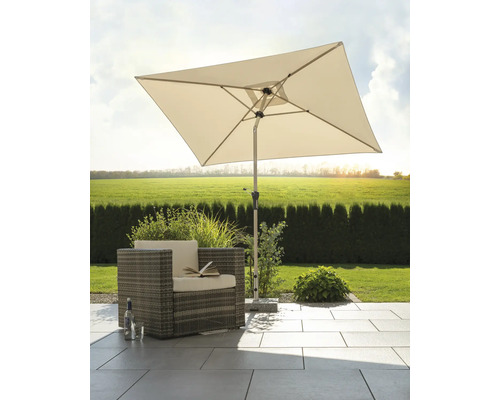 Scène avec un parasol carré, un fauteuil en rotin et des dalles de sol dans le jardin