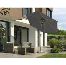 Gartenlounge mit Gartenschirm auf Terrasse vor modernem Haus