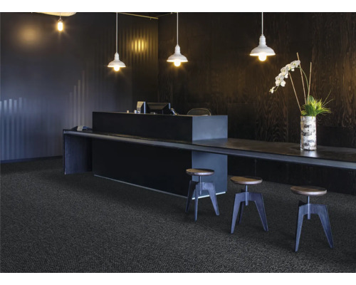 Scène avec moquette foncée, comptoir, tabourets et éclairage pour une ambiance de bureau moderne.