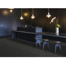 Réception avec moquette, bureau et tabourets de bar sous des suspensions