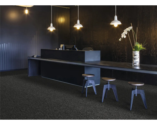 Réception avec moquette, bureau et tabourets de bar sous des suspensions