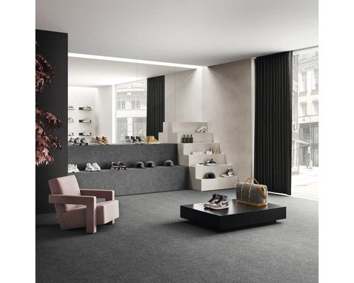 Espace de vente spacieux avec chaussures, fauteuils et escalier décoratif