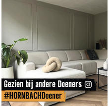 Wohnzimmer mit großem Ecksofa, Zimmerpflanze und Wandpaneelen
