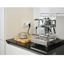 Espressomaschine aus Edelstahl auf Küchentheke mit Tasse und Schneidebrett