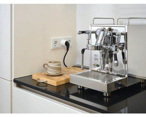 Espressomaschine aus Edelstahl auf Küchentheke mit Tasse und Schneidebrett