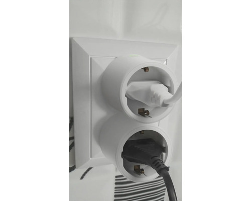 Zwei Steckeradapter mit eingesteckten Stromkabeln in einer Steckdose