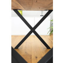 Detailansicht eines Tisches mit schwarzem Metallgestell in X-Form.